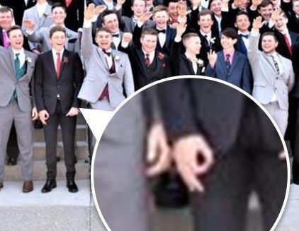 One of the students appears to make a symbol with his hand that has been linked to the racist phrase ‘white power’