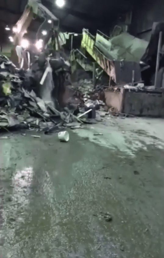  The digger pulls up a chunk of debris from the pile before the first rat darts out from under the rubble