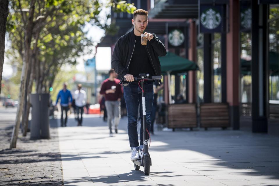  Riders stand on the scooters and pull a handlebar lever to start an electric motor