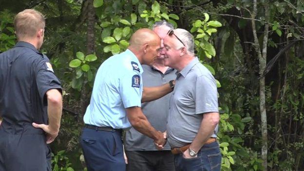  David Millane pictured with a police officer taking part in a Maori blessing near where Grace's body was discovered