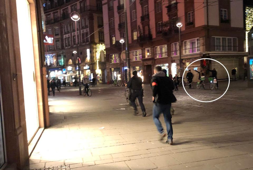  Cyclists appear to point to where the shots were heard