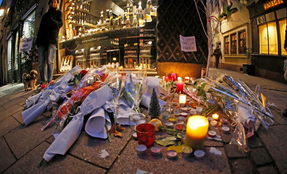  Candles, flowers and a sign reading 'All united against barbarity' are left where a person was killed during the Christmas Market massacre