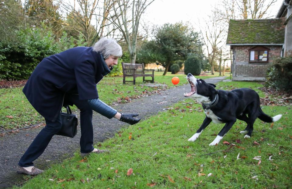  Mrs May playing with a dog outside her local church this morning