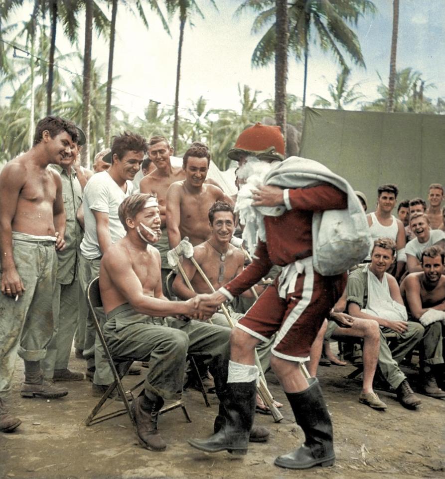  Santa Claus wearing a helmet and handing out presents to wounded American soldiers on Christmas Day