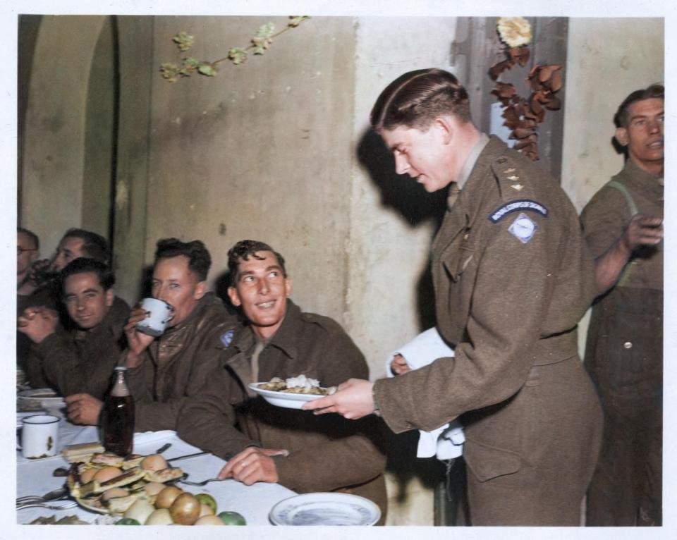  Soldiers sitting around a table to share their Christmas dinner