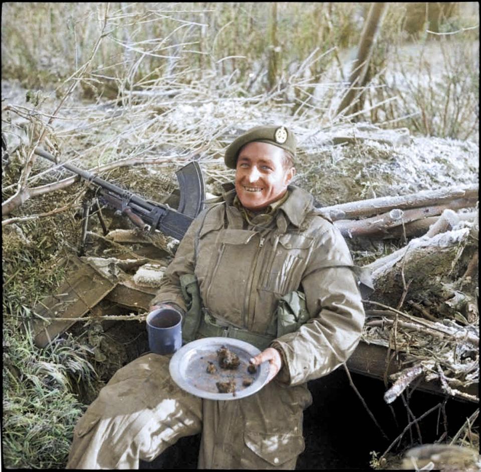  A British soldier beams as he tucks into a Christmas meal while on the front line