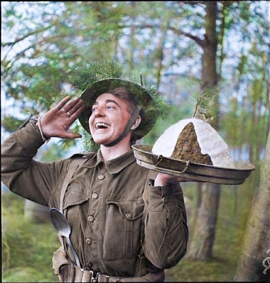  Gunner H S Hadlow of 15th Scottish Division in Holland announcing to fellow soldier's that the Christmas pudding is ready in 1944