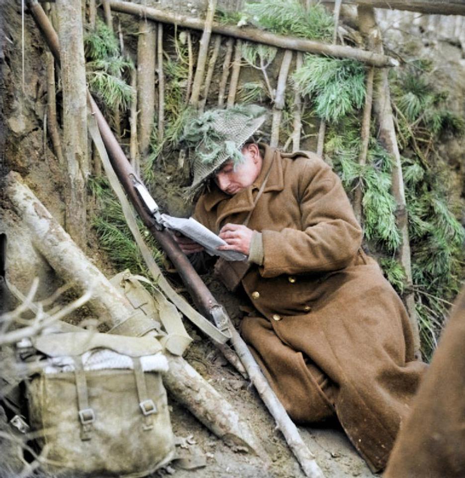  Private Thomas Childs of 1st Herefordshire Regiment, 11th Armoured Division, reads a letter from home in his dug-out near Sonsbeck, Germany in 1945