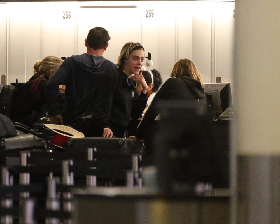  Cara was pictured queuing at check in and put their bags through before heading to wait with the other passengers