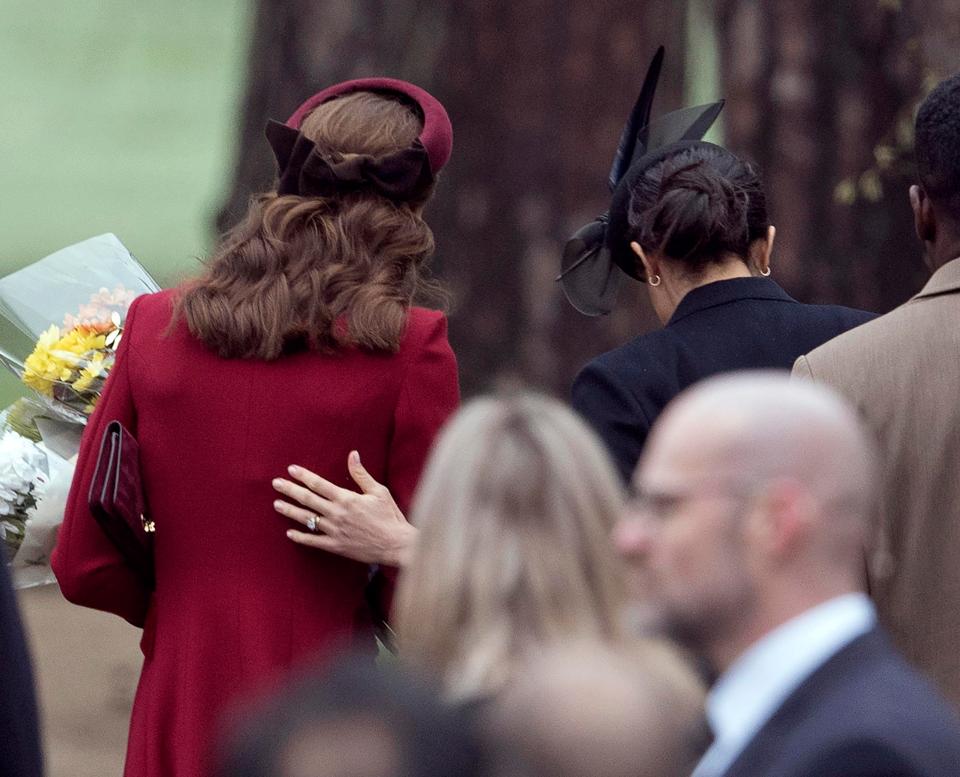  Meghan Markle placed her hand on Kate Middleton's shoulder as they left Sandringham today