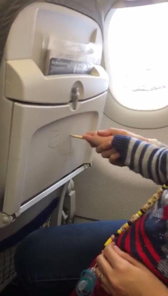  A parent watched as her child scribbled on the tray tables in front of them