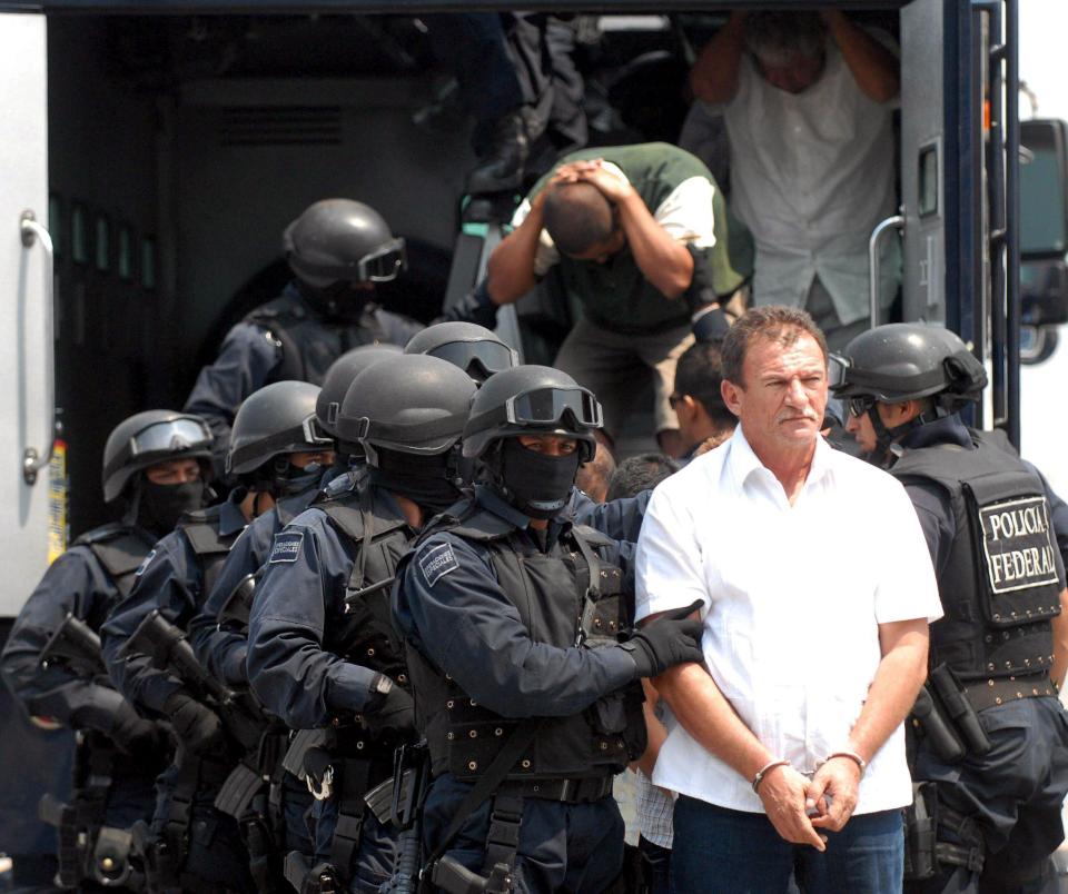 Mexican policemen escort alleged members of the La Familia Michoacana drug cartel in Mexico City