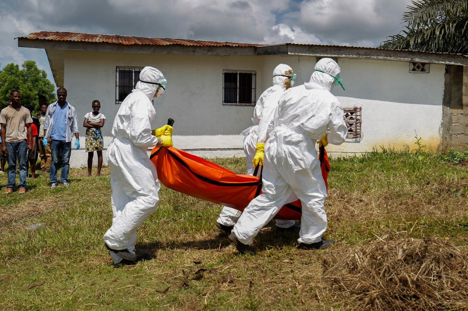 a group of people in protective suits are carrying a body