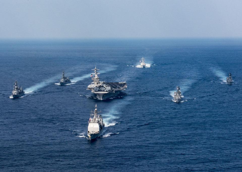  The Nimitz-class aircraft carrier USS Carl Vinson surrounded by a fleet of warships in the Philippine Sea