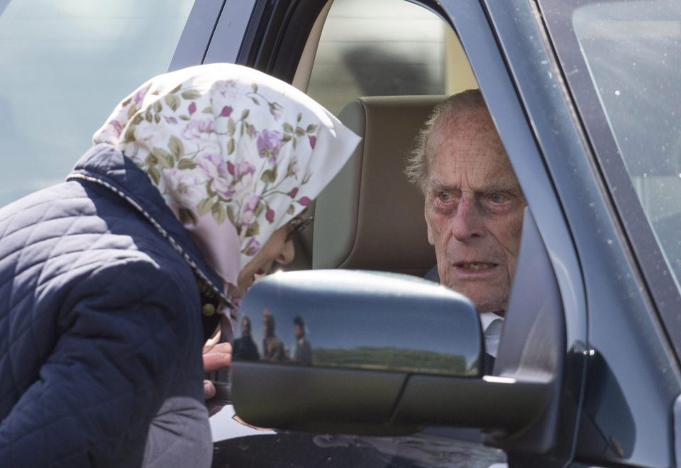  Philip at the wheel of his Land Rover speaks to the Queen through the window