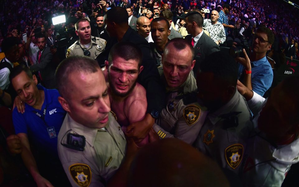 Khabib was shepherded away by police and security as all hell broke loose