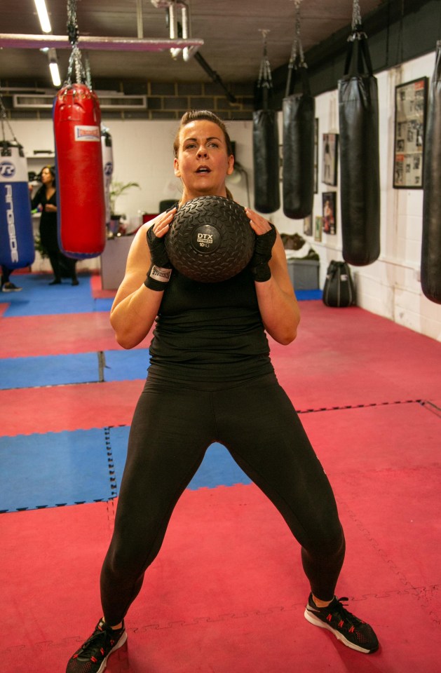 Rebecca with a heavy weighted medicine ball does ­sit-ups, slams and Russian twists