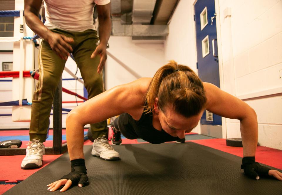  Rebecca soldiers through Clinton's tough boxing regime doing push-ups on the mat