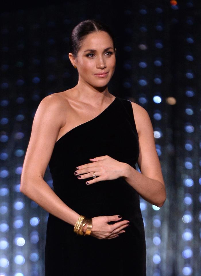  Meghan cradled her bump with both hands at the British Fashion Awards