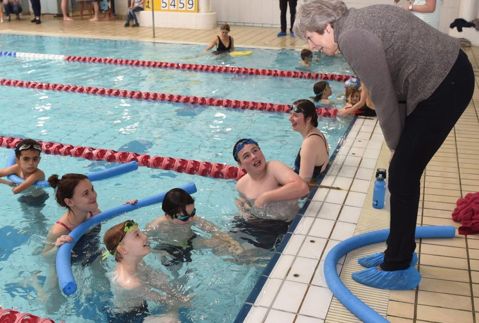  Theresa May, who has warned of No Deal Brexit chaos, chats to competitors on annual visit to swimming gala