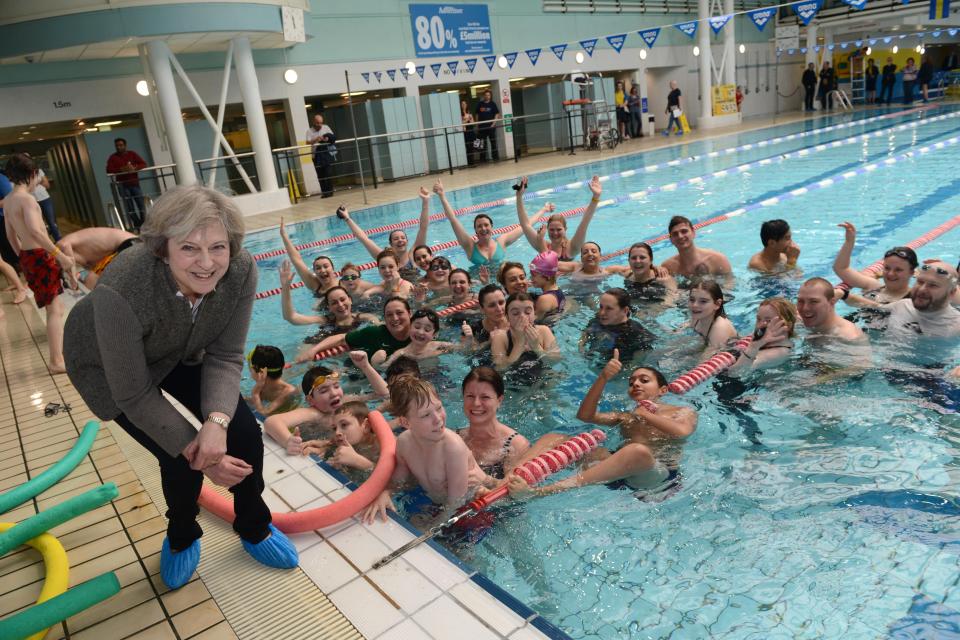  Theresa May smiles as she poses with swimmers at an event in Maidenhead in 2017