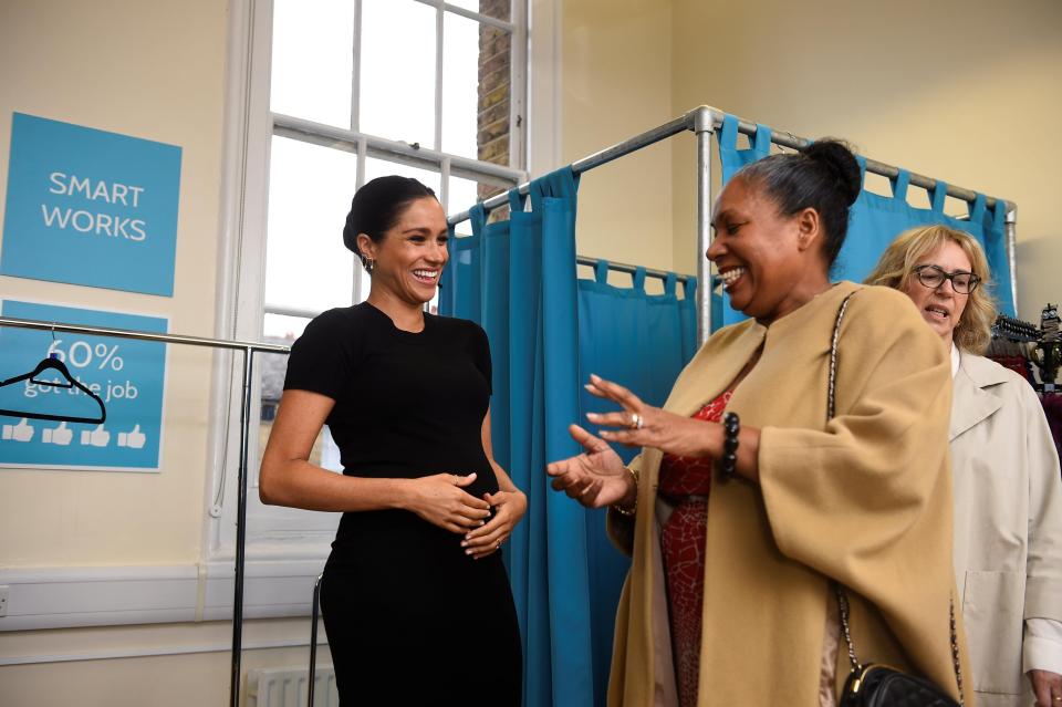  Meghan was also seen "hugging" her bump yesterday