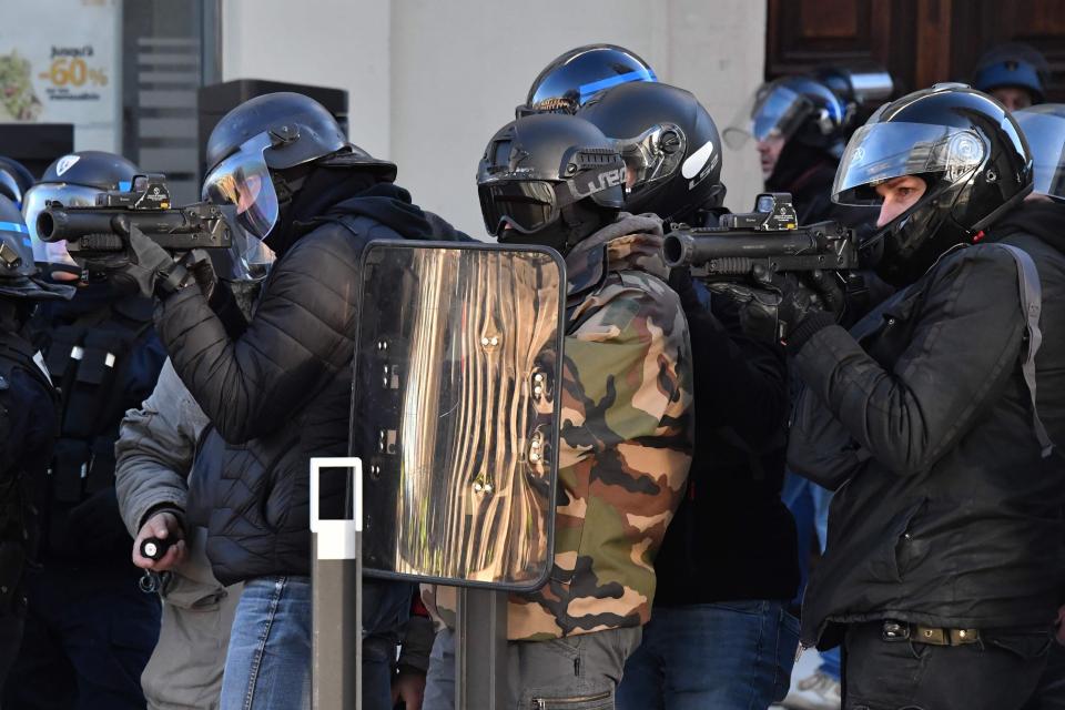  Plain-clothes policemen aim with a non-lethal hand-held weapon (LBD40) during an anti-government demonstration