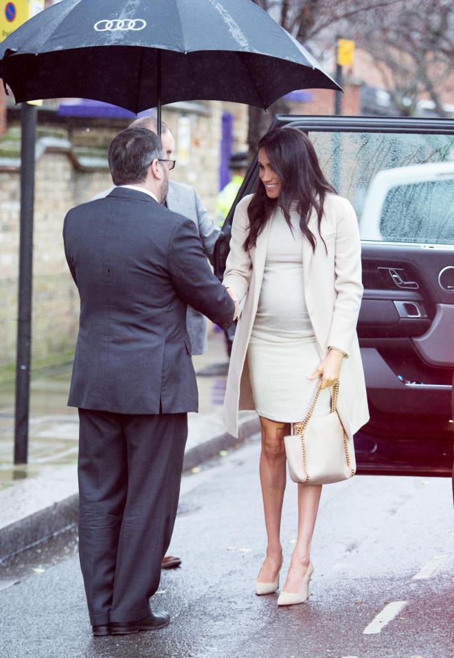  Meghan was saved from the rain with a large umbrella as she was greeted