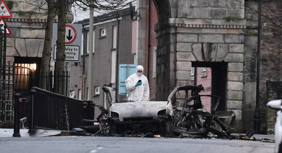  An investigator with the twisted wreckage of the van used in a car bombing in Londonderry