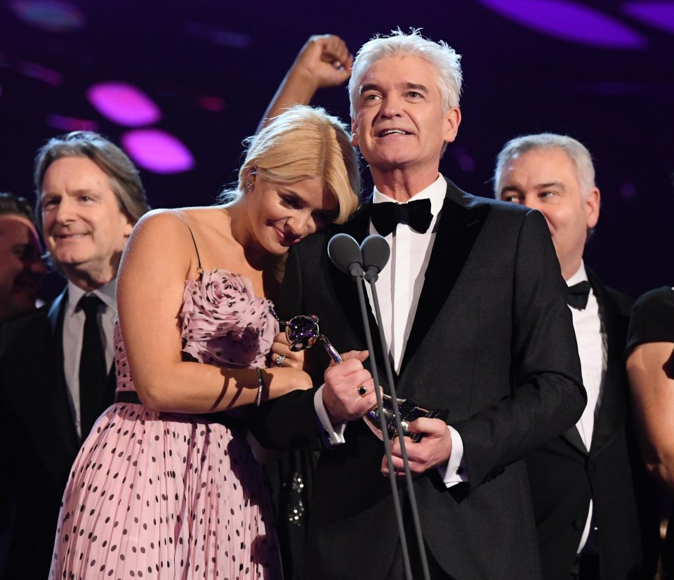 Holly cuddles on-screen hubby Phil as they pick up the NTA award