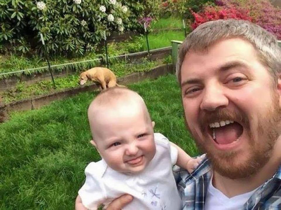  This dad perfectly captured the moment his dog took a poo behind his baby's head