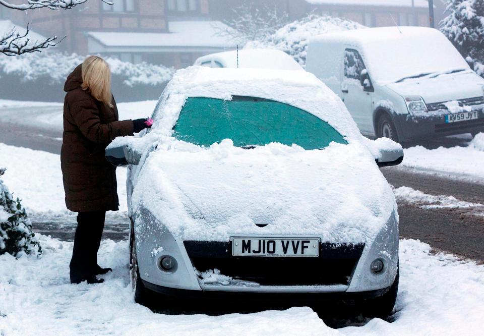  A woman clears the snow and ice from her car yesterday morning in Rochdale, Greater Manchester