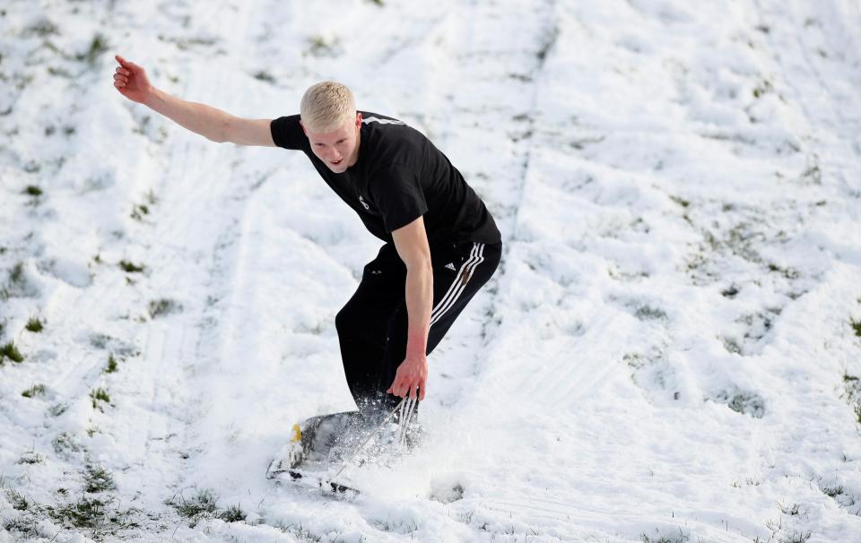  Young men sledge in the snow at Moss Farm Leisure Complex in Northwich