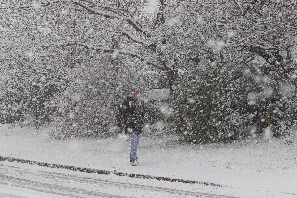  A walker braves the heavy snowfall on the streets of Reruth, Cornwall, earlier today