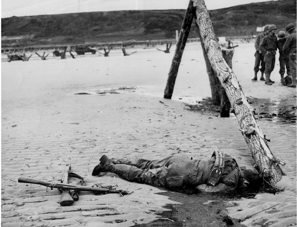  A corpse lies washed up against sea defences in Normandy, France