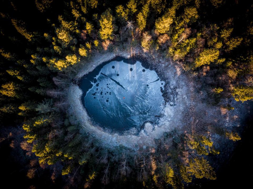 Aerial view of a small frozen forest lake in Oslo, Norway