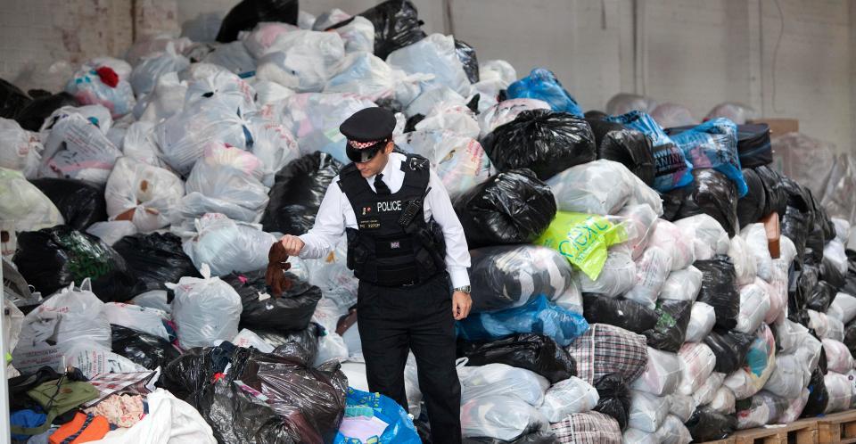  A police officer in front of seized charity bags from scammers