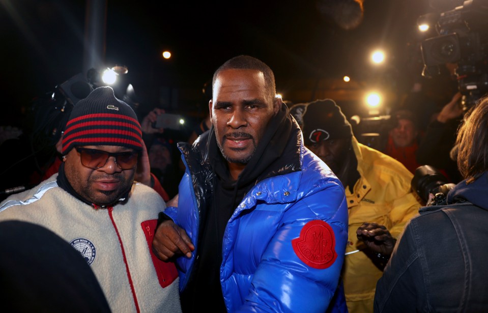  R Kelly, centre, handed himself in to police in Chicago on Friday evening