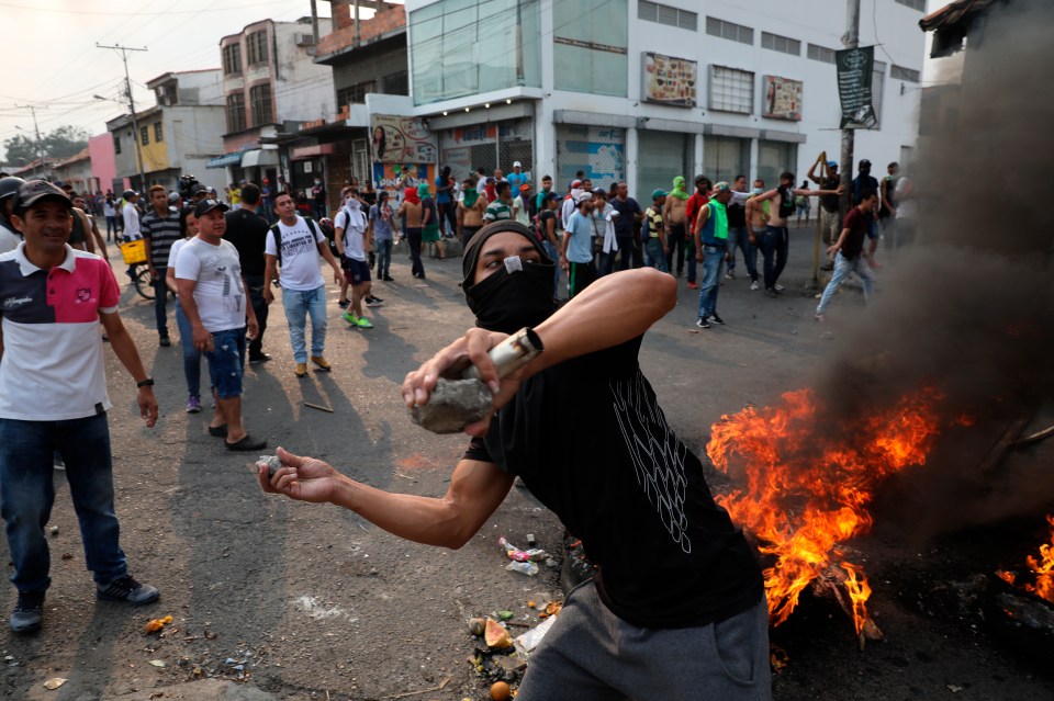  A protester throwing rocks at the National Guard in Urena, Venezuela, where workers clashed with soldiers after attempting to cross into Colombia