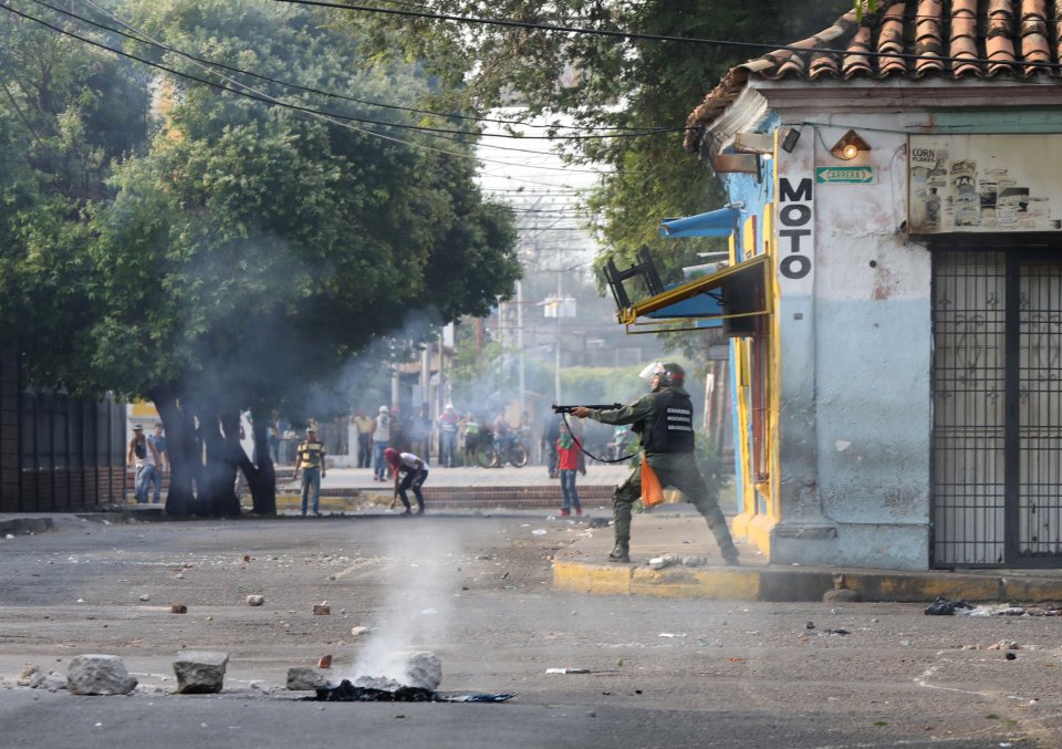  A troop aiming his shotgun during the violent clashes with civilians who are fighting against the Maduro-imposed blockade on foreign aid