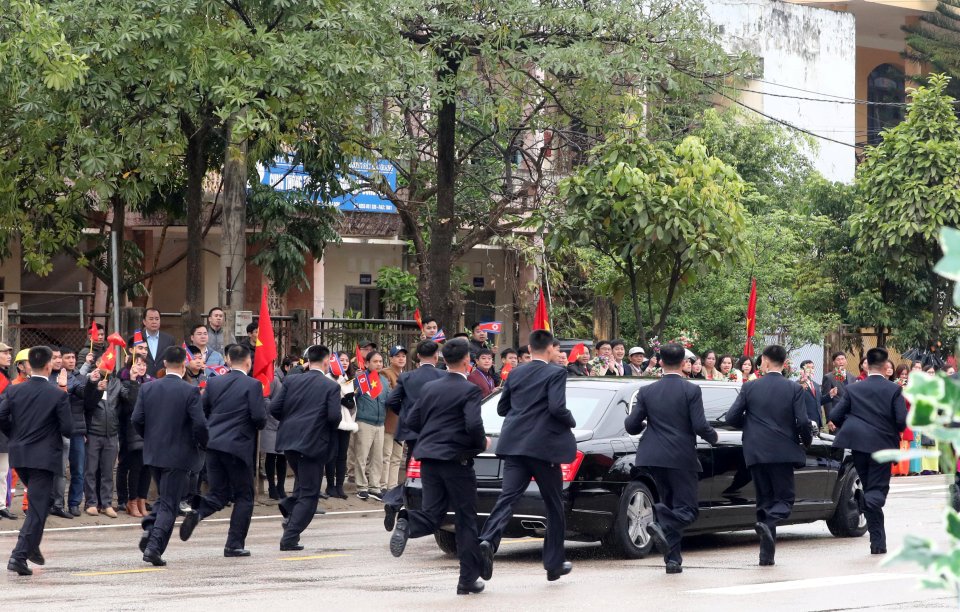  Suited and well-armed bodyguards follow the limo's every turn