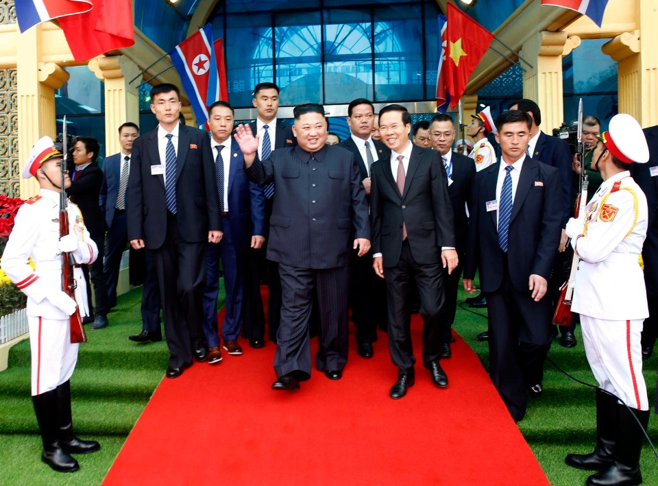  The leader grins as he walks along a red carpet in Hanoi