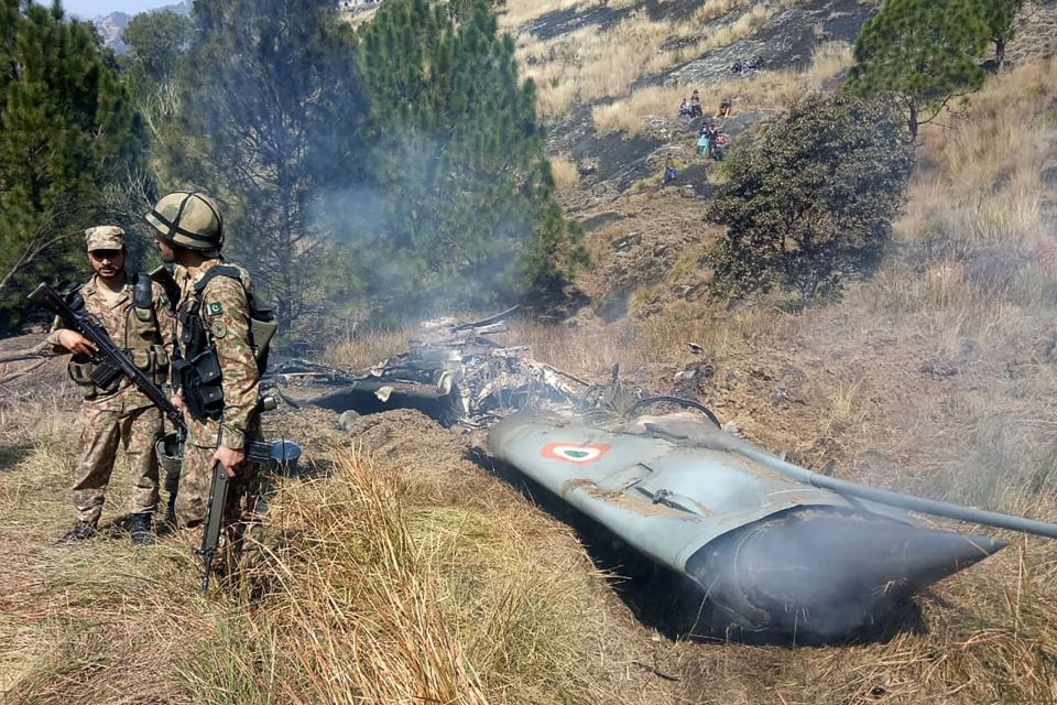  Pakistani soldiers stand next to what Pakistan says is the wreckage of an Indian fighter jet shot down in Pakistan controled Kashmir