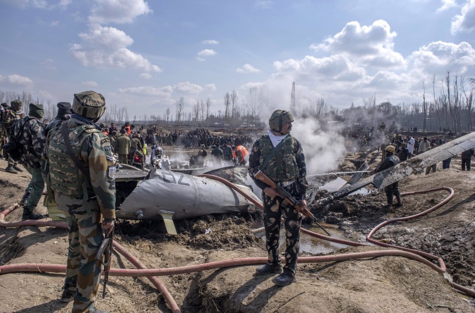  Indian military forces survey the scene of the crashed Indian jet which killed six people