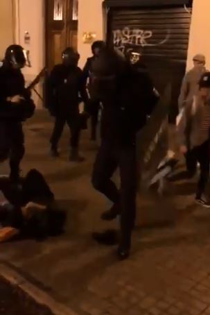  The cop is seen stamping on the headphones as the man rolls around on the floor