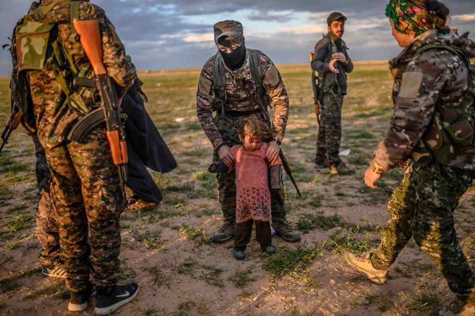  A toddler waits during a security check of her and her mother