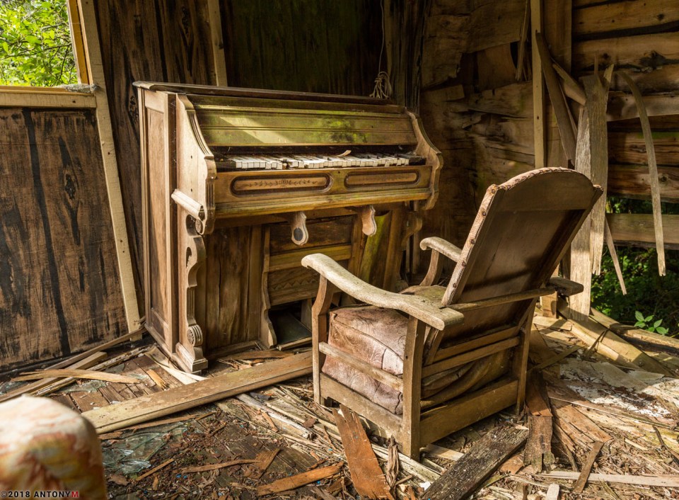 An broken piano sits in one of the themed rooms as the wood is decaying