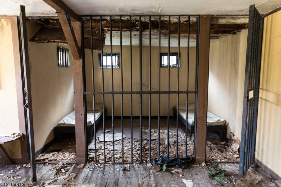 Leaves and debris litter what was once an open jail cell in the park 