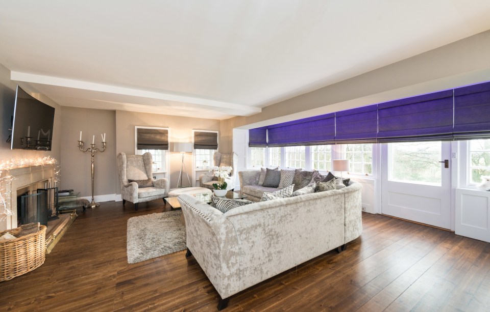  This living room features solid wood floors and large windows onlooking the Scottish countryside