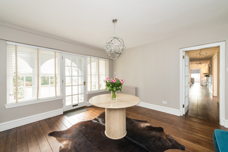  This grand entrance hall features a central table and large animal skin rug